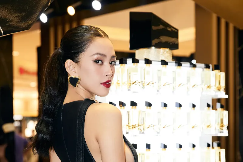 Người phụ nữ xịt nước hoa Yves Saint Laurent lên cổ tay, tạo dáng thanh lịch và quyến rũ